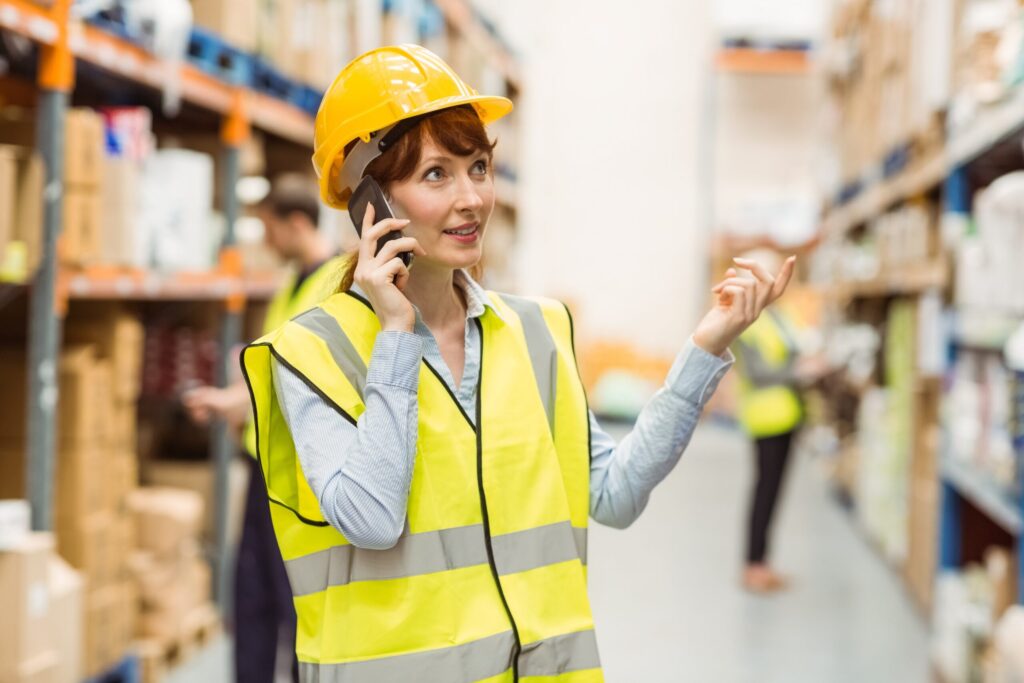 Warehouse manager talking on the phone looking around